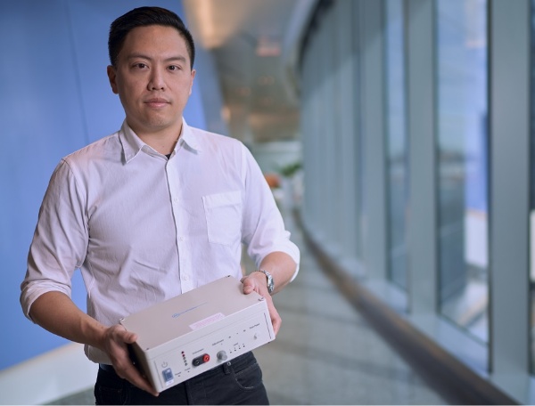 Albert Huang holds his StimSite device